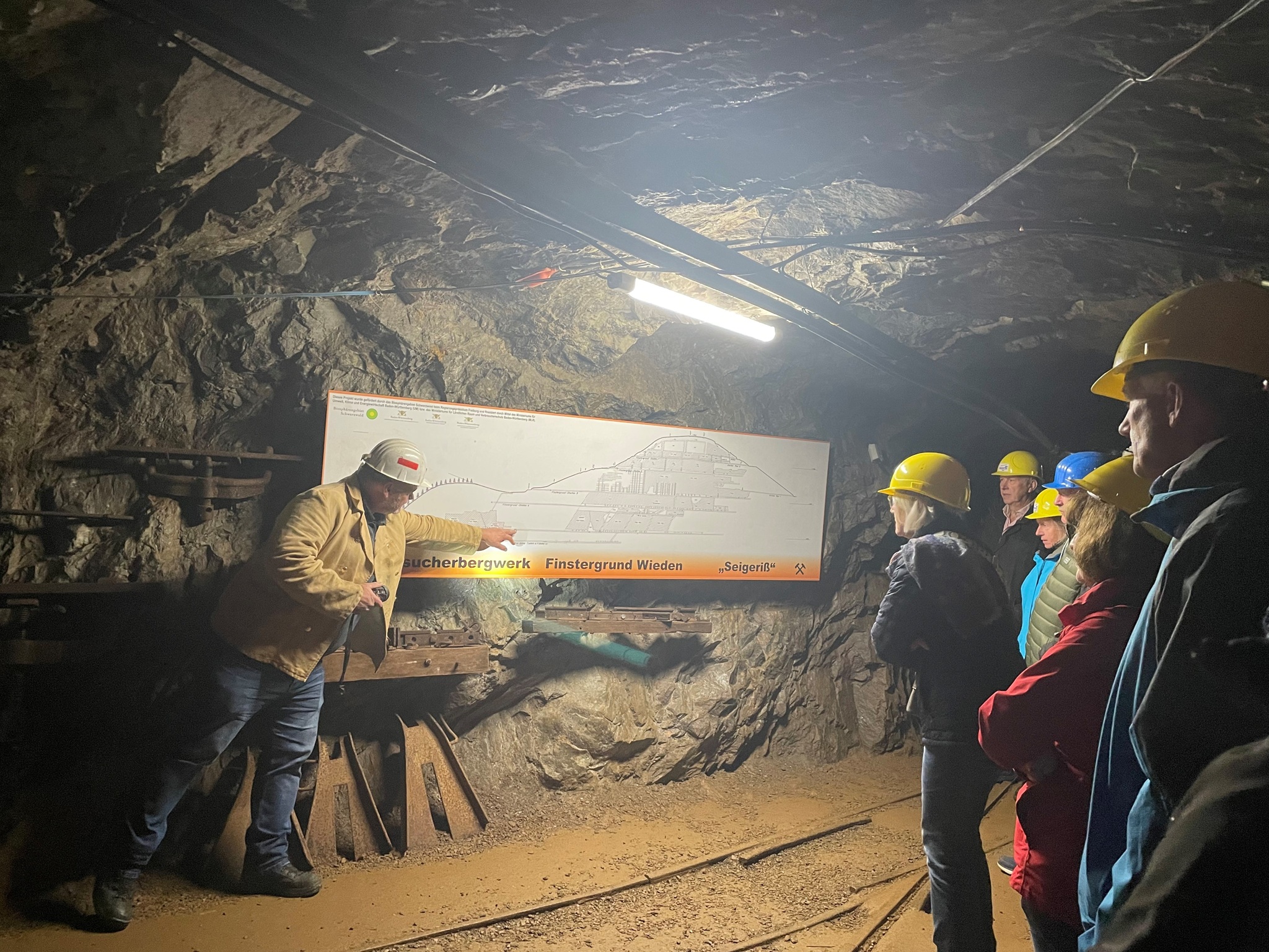 Führung im Besucherbergwerk Finstergrund in Wieden: Gruppenführung unter Tage mit Erklärung eines Grubenplans
