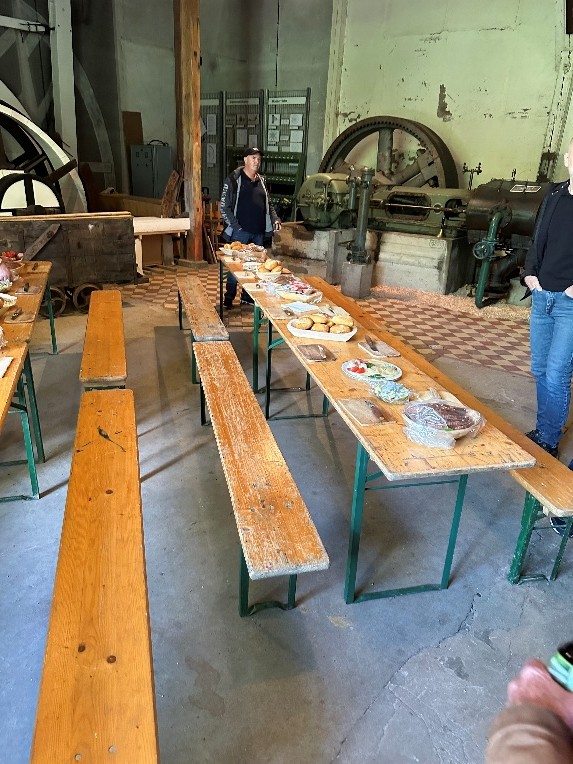 Frühstückstafel mit Brötchen und Aufschnitt in einer historischen Maschinenhalle mit alten Industrieanlagen