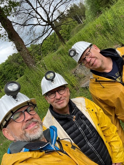 Der Vorstand in gelben Bergmannsjacken und Helmen mit Grubenlampen bei einem Ausflug ins Grüne