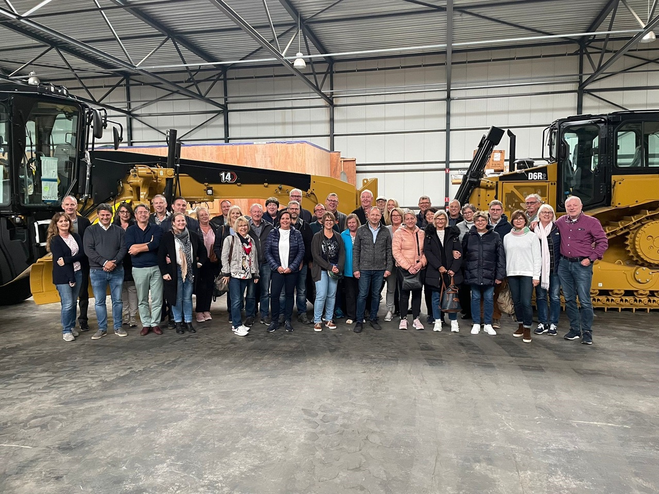 Gruppenfoto der Bezirksgruppe Garzweiler bei einer Werksbesichtigung mit Baumaschinen im Hintergrund